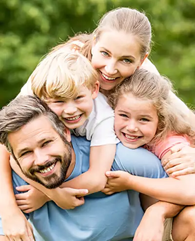 A family smiling while hugging each other.